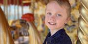 A young child on the Clarence Pier Amusement Park carousel
