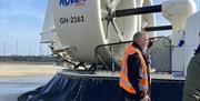 A tour guide showing visitors around the hovercraft