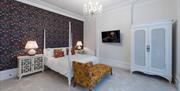 Modern four-poster bed in a room at The Clarence Boutique Rooms