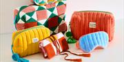 An array of colourful Oliver Bonas bags and travel items