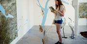 Person reading a sheet of paper in front of an exhibition at Aspex Portsmouth, by photographer Tom Langford