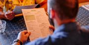 A man reads the Pizza Express Gunwharf Quays menu