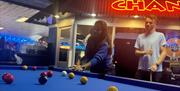 Two people playing pool at Clarence Pier Amusement Park
