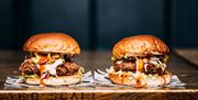 Two burgers on a serving board at Hub Box