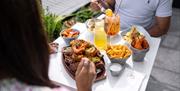 Two people enjoying al fresco food from Tap & Tandoor