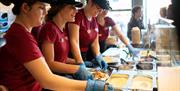 Tortilla crew members behind the counter preparing meals.