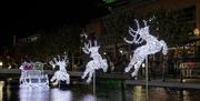 Santa's sleigh and reindeer in lights on the water at Gunwharf Quays