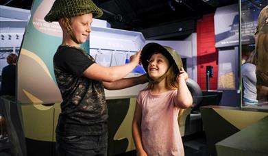 Children trying on helmets at the D-Day Story