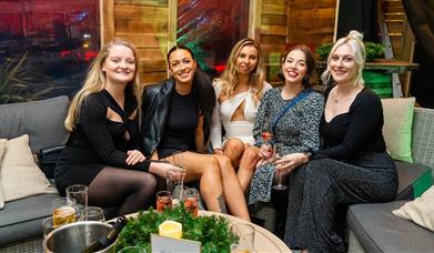 A group of five women enjoying the Winter Lodge at the Queens Hotel