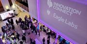 An event with the Innovation Connect and Eagle Labs branding on a large screen above the attendees