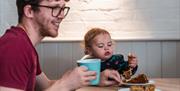 A man and child enjoying food at the Staunton Farm cafe