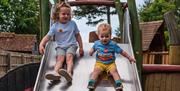 Children on a metal slide at George's Play Barn in Staunton Farm
