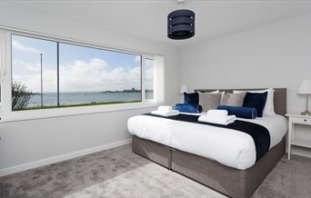 Bedroom with a coastal view from Oliverball Serviced Apartments