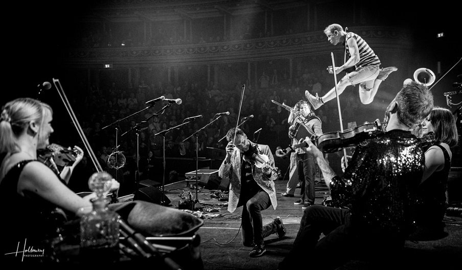 Black and white photograph showing a Bellowhead gig in full swing