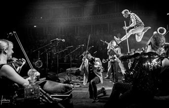 Black and white photograph showing a Bellowhead gig in full swing