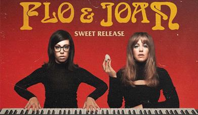Press photograph for Flo & Joan: Sweet Release showing the two comedians sat behind a piano