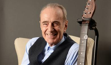 Press shot for Francis Rossi: Tunes & Chat, featuring the singer and an acoustic guitar