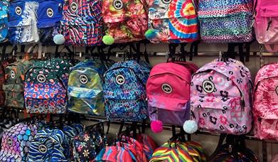 Colourful backpacks lined up on racks at the Hype outlet in Gunwharf Quays