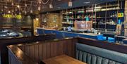 The interior of Tap & Tandoor Gunwharf Quays featuring booth seating and the bar