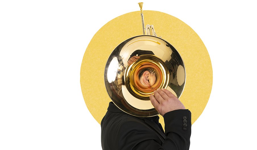 A member of the Bournemouth Symphony Orchestra holding up a brass instrument
