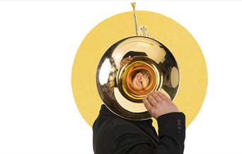 A member of the Bournemouth Symphony Orchestra holding up a brass instrument