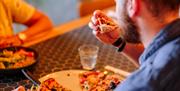 A man tucks into pizza at Pizza Express Gunwharf
