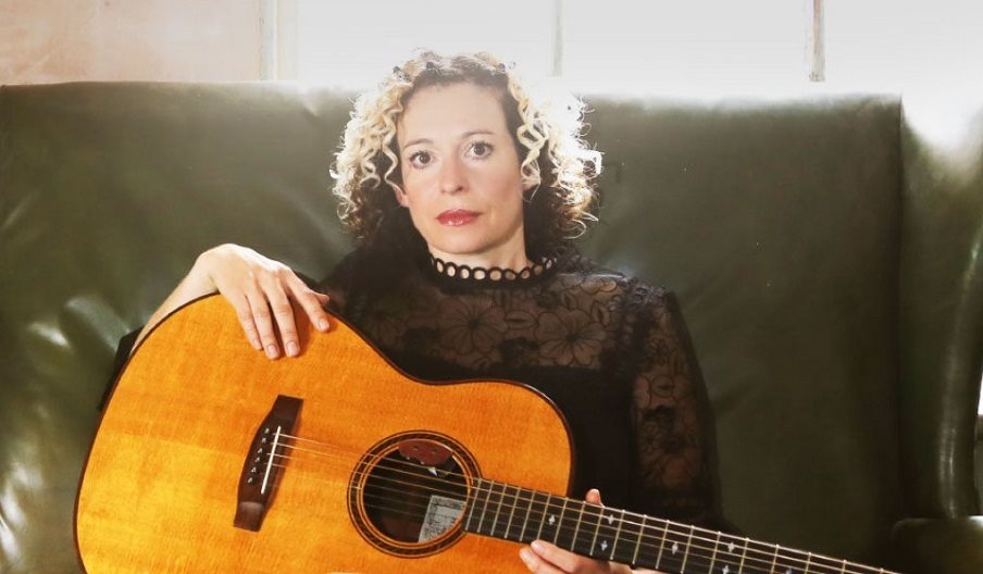Press photo of Kate Rusby holding a guitar