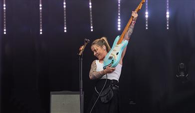 Lucy Spraggan playing guitar on stage