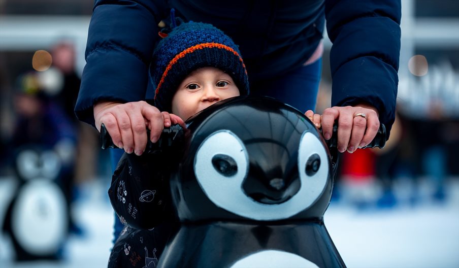 Child with a penguin-shaped skate aid at Ice Skate Portsmouth - credit Ice Skate Portsmouth and Vernon Nash