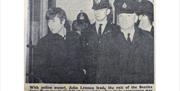 Old photograph showing police officers escorting a young John Lennon out of Portsmouth Guildhall