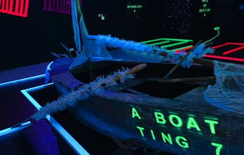 Inside Zingers Adventure Golf, with a boat lit up in UV paint