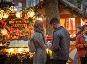 Man and woman stood outside in Reading's Christmas Market on Broad Street