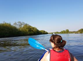 Lady canoeing alone along the River Thames on a sunny day