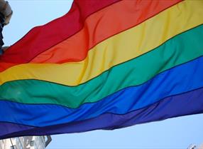 Pride festival flag with rainbow colours flying in the sky.