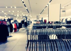 Row of clothes hanging on a rack in the interior of a shopping centre