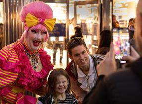 Pantomime dame in Reading taking a selfie with children