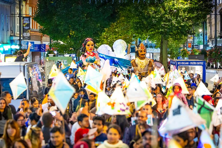 Crowd celebrating Diwali carrying lanterns through Reading's Broad Street