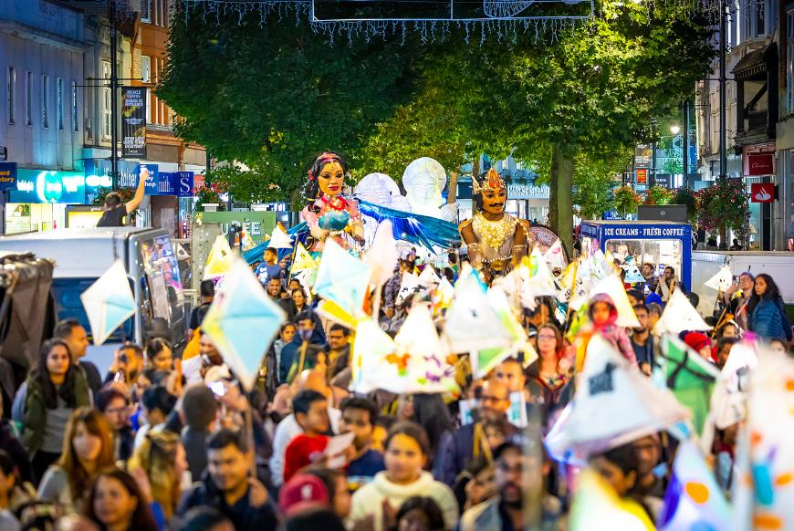 Crowd celebrating Diwali carrying lanterns through Reading's Broad Street