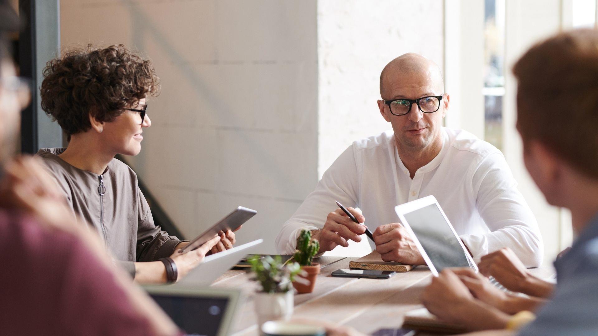 Group of young professionals sat around a table in a collaborative business meeting