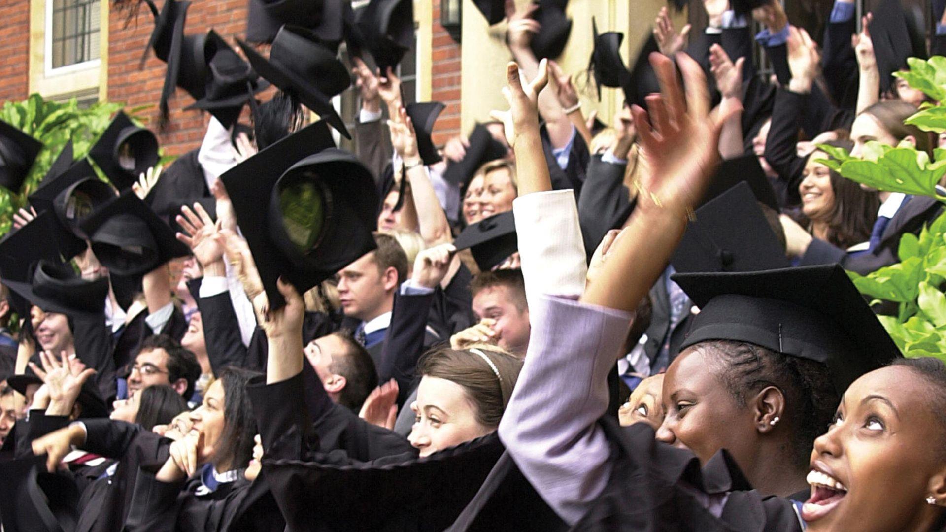 graduates throwing hats into the air