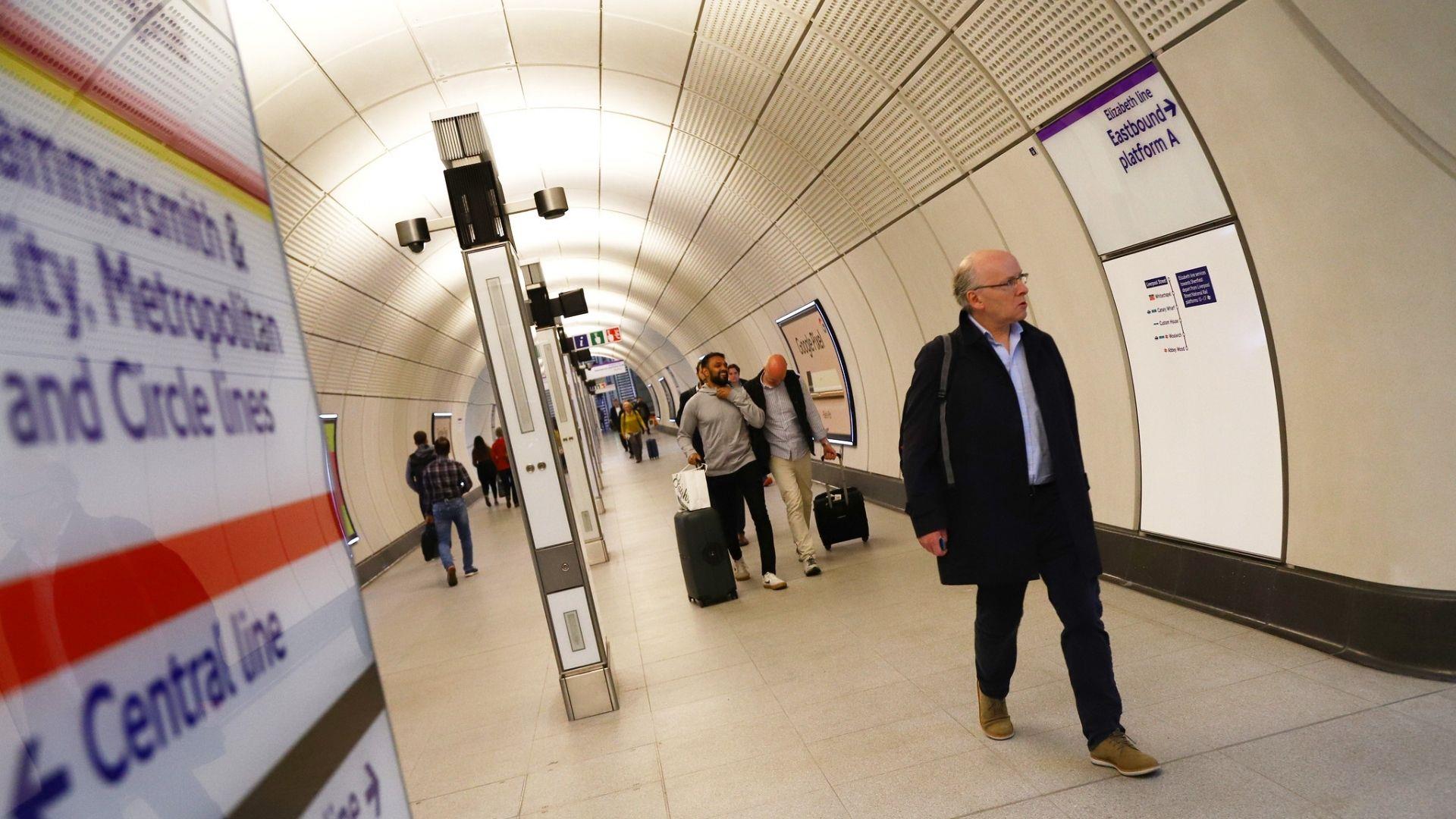 people walking along tube corridor