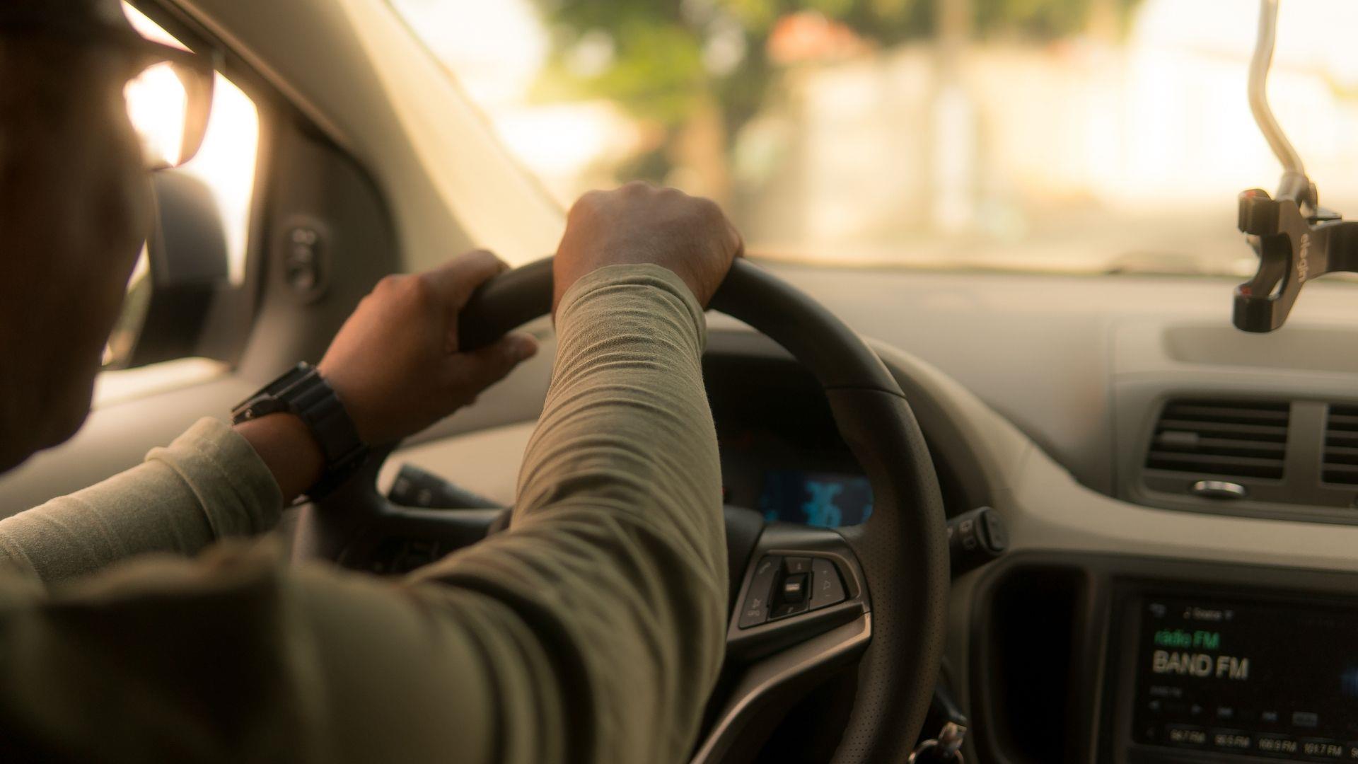 Man driving car, close up shot of steering wheel