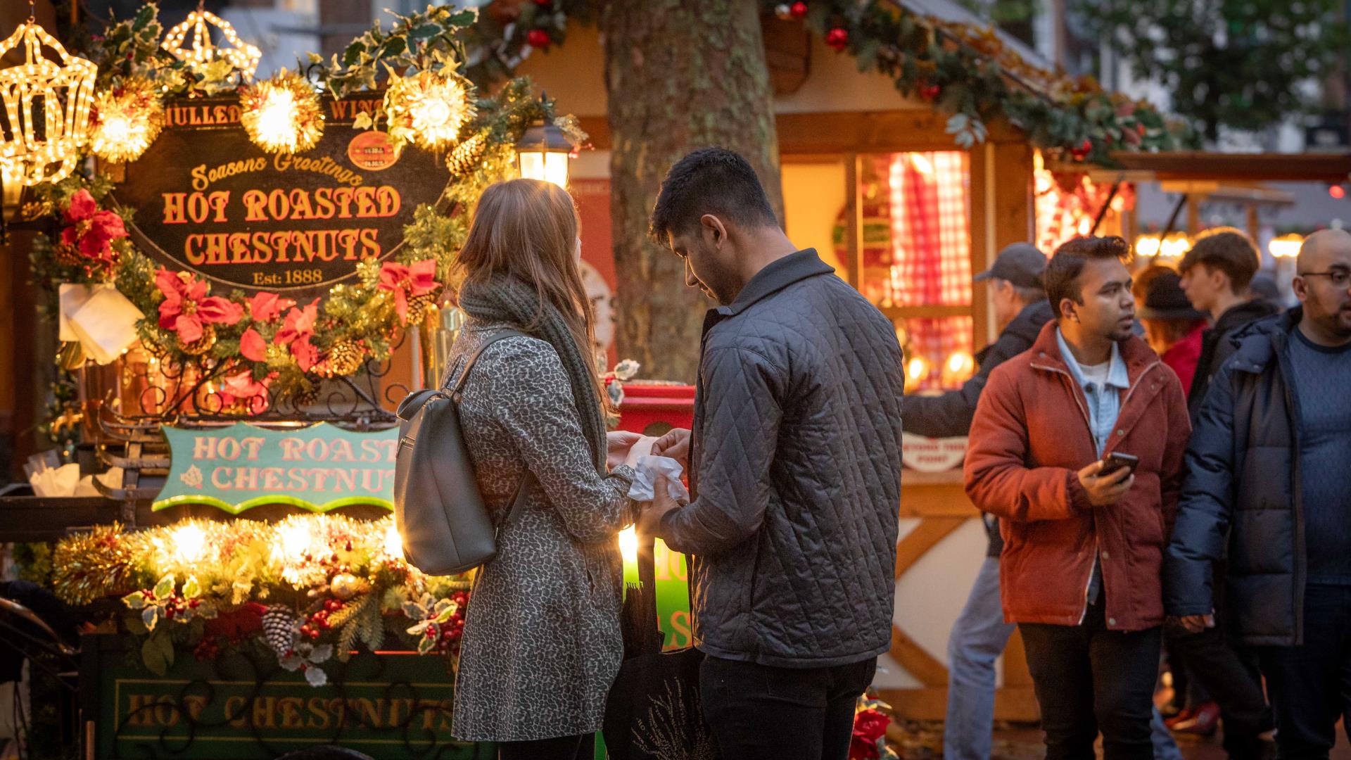 Man and woman stood outside in Reading's Christmas Market on Broad Street