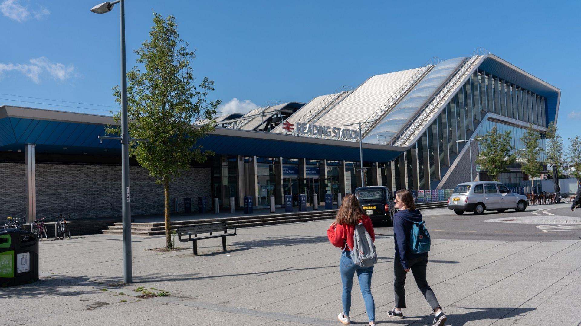 Two girls walking towards Reading Station on a sunny day