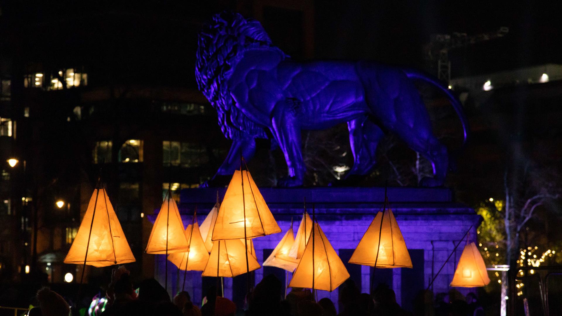 Lanterns glowing in Forbury Gardens in Reading, in front of the Maiwand Lion