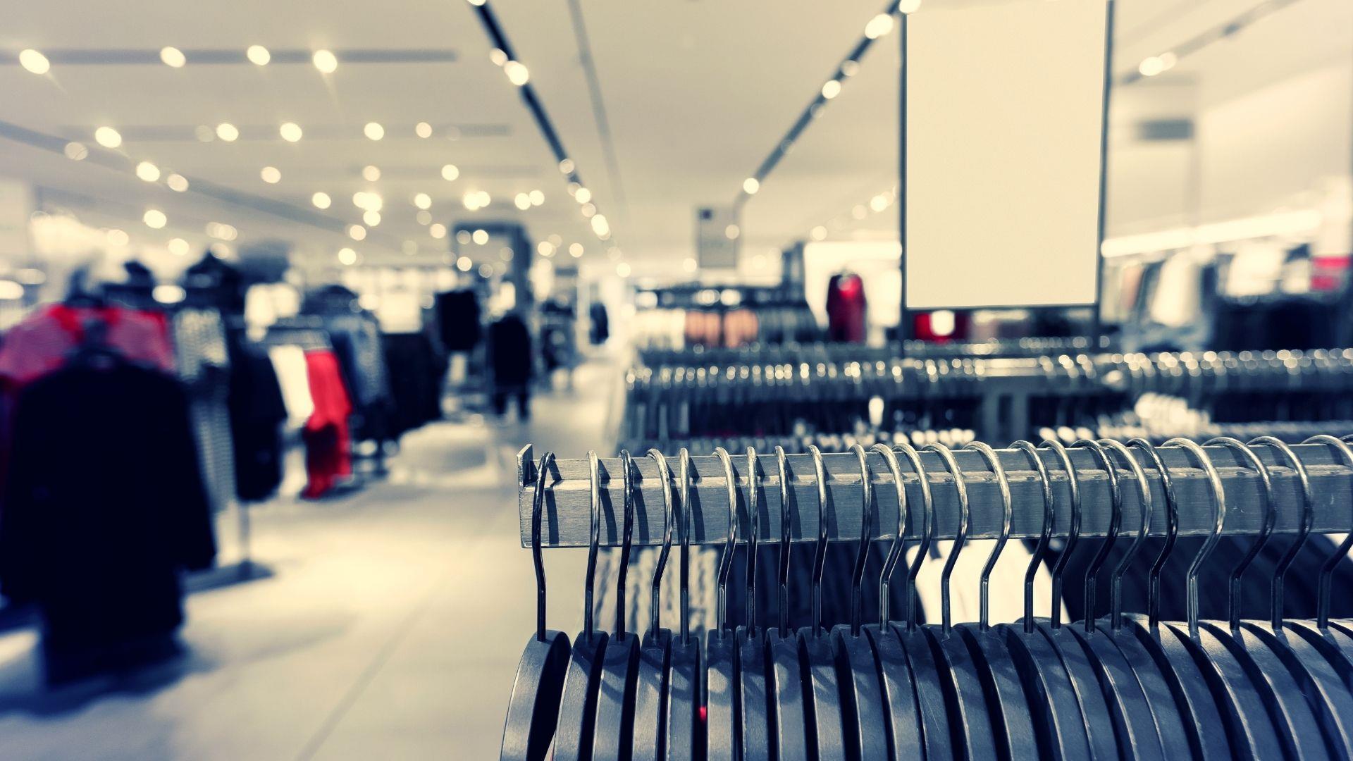 Row of clothes hanging on a rack in the interior of a shopping centre