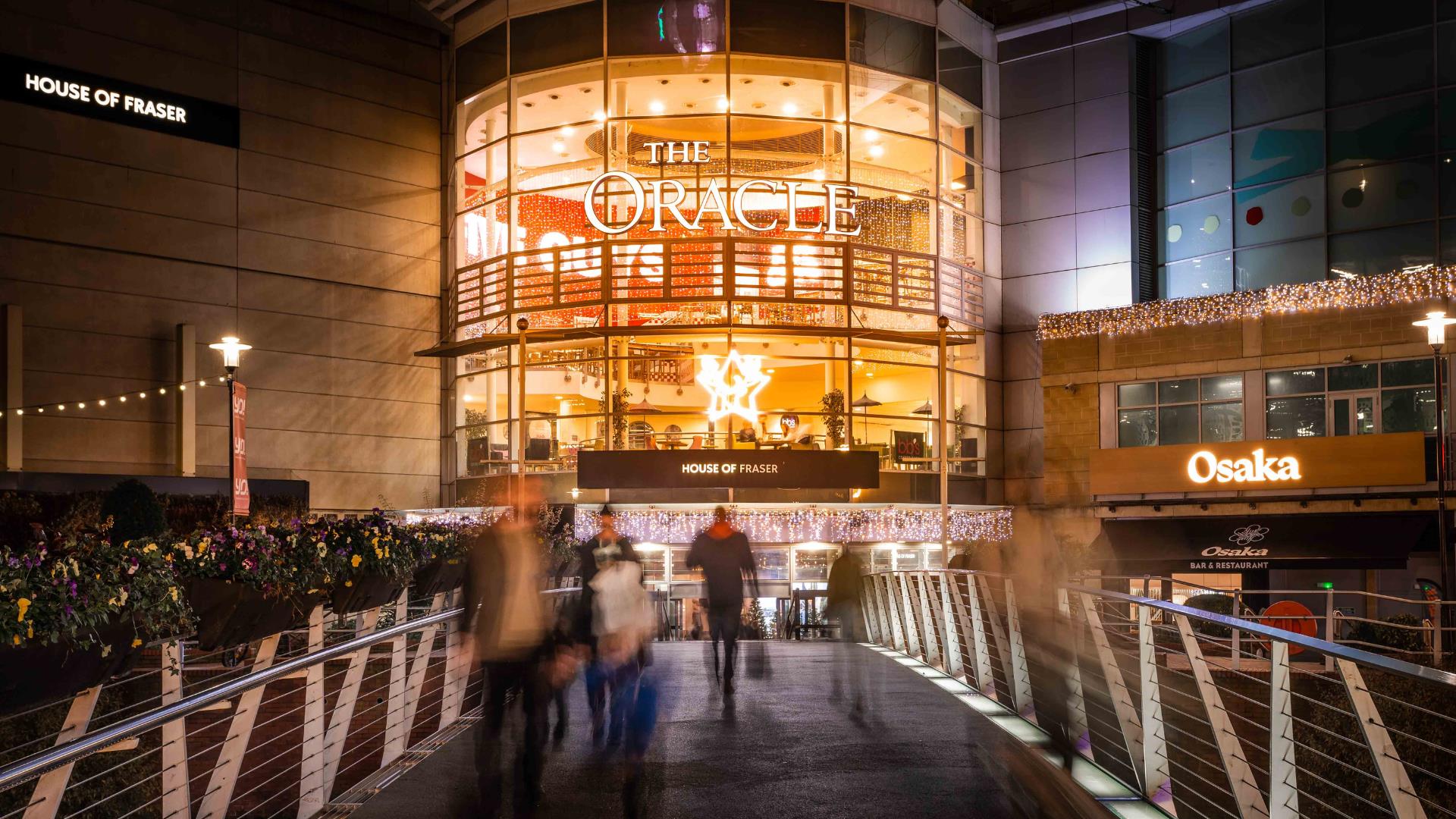 Blurred shot of shoppers walking over the bridge at the Oracle Shopping Centre at Christmas time