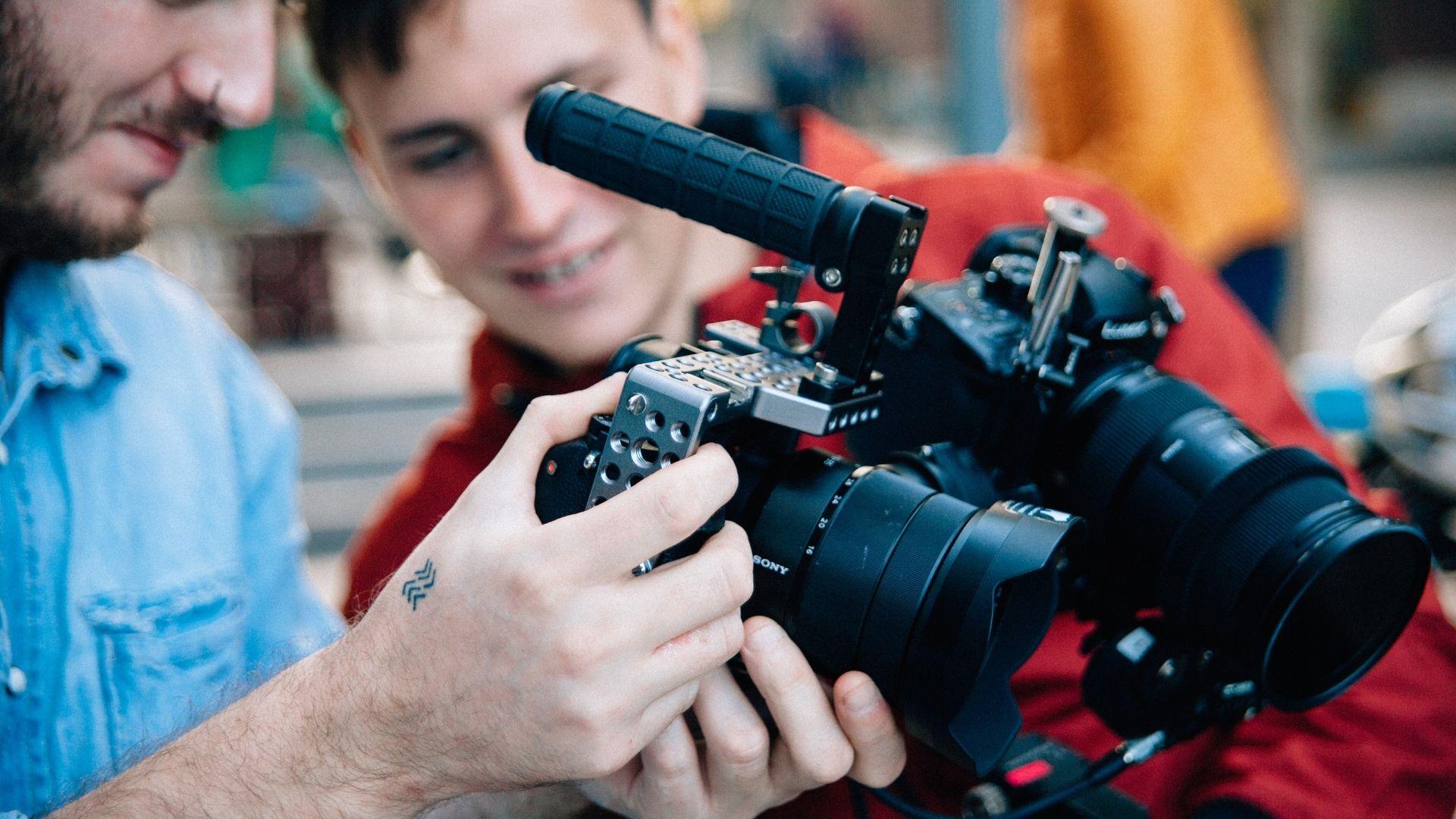 Two men holding a film camera