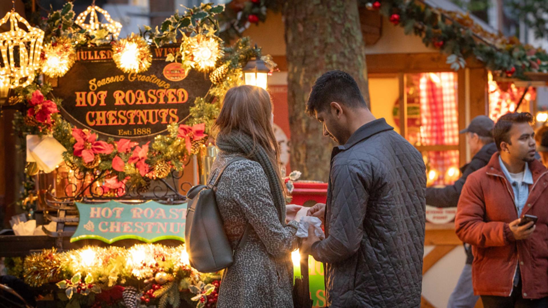 Man and woman stood outside in Reading's Christmas Market on Broad Street