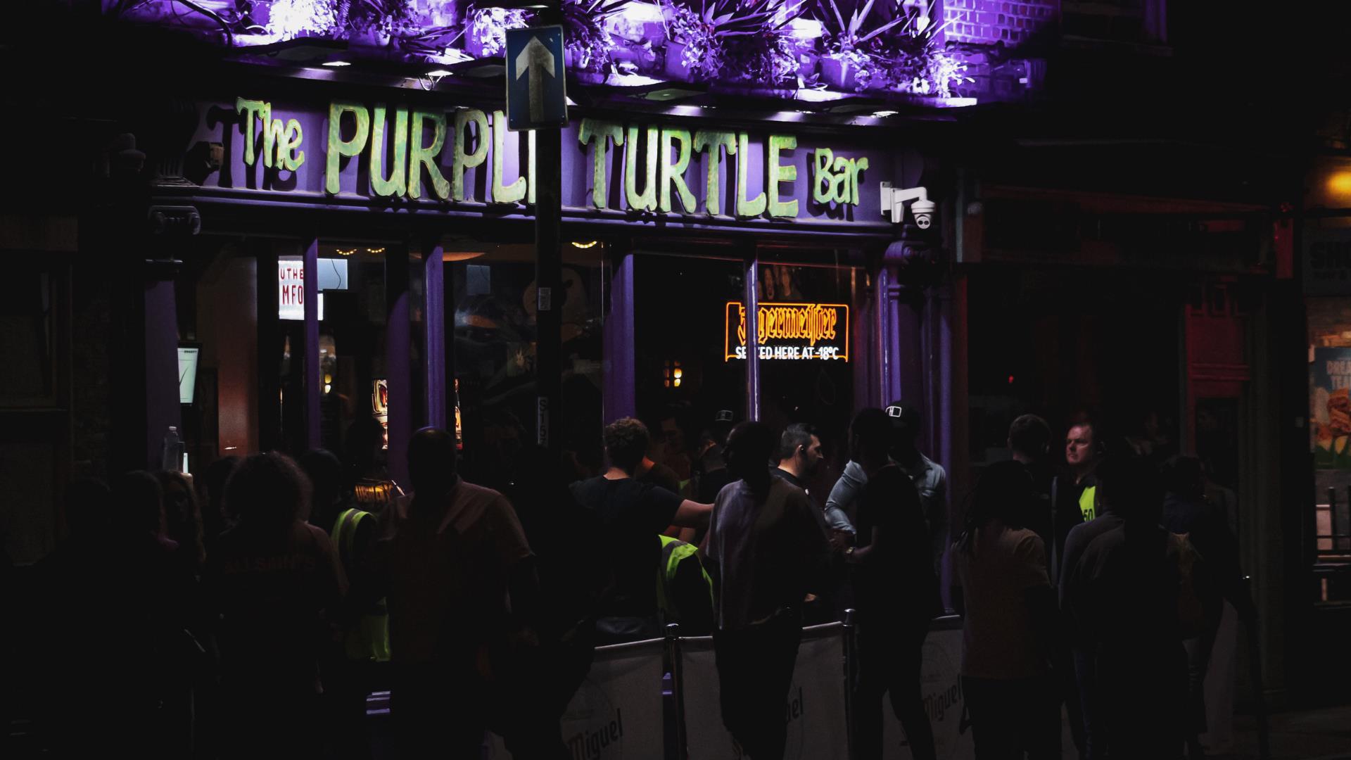 Exterior shot of people queued outside of purple Turtle bar